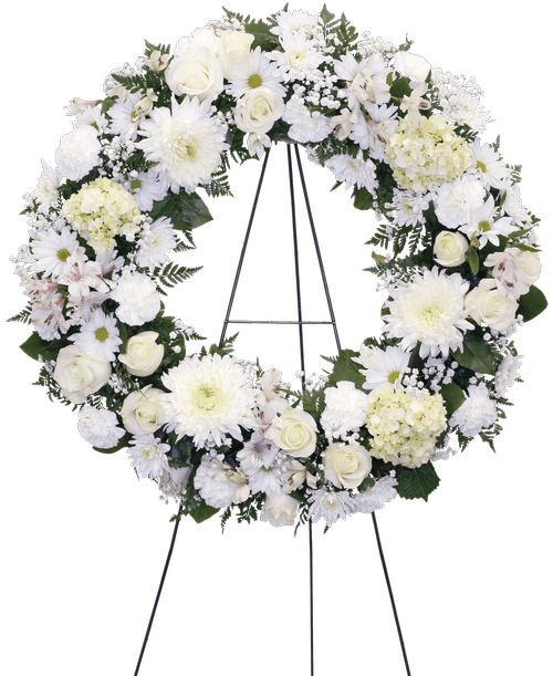 A wreath, suitable to be sent to a funeral or memorial service, is designed in whites including roses, football mums, carnations, alstroemeria, daisy poms, cushion poms, mini green hydrangea, and baby's breath. 26 inchD - Displayed on a 60 inch Easel