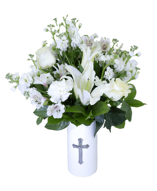 An 8 inchH white ceramic vase with a cross holds a 3/4 round arrangement in all whites including stock, a lily, two roses, alstroemeria, and carnations. 20 inchH x 17 inchW