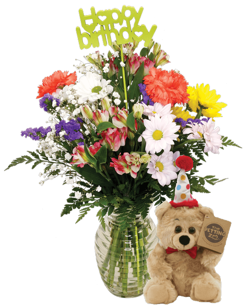 A 7.25 inchH clear glass vase with a horizontal design holds an all-around arrangement with charmelia alstroemeria, carnations, mini carnations, daisy poms, baby's breath, and statice, a inchHappy Birthday inch stick-in, and includes a 10 inchH inch tan plush bear with a party hat. 16 inchH x 12 inchW; Overall 19 inchH