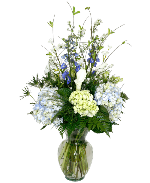 An 11 inch glass vase holds an all-around arrangement with hydrangea, mini calla lilies, mini green hydrangea, charmelia alstroemeria, delphinium, eryngium, and includes a silk wildflower spray. 20 inchH x 20 inchW; overall 30 inchH