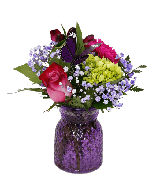 A 5.5 inchH lavender glass vase with a diamond pattern holds an all-around arrangement with a mini green hydrangea, alstroemeria, a carnation, a rose, purple-dyed baby's breath, and includes a butterfly stick-in. Overall 10 inchH x 8 inchW
