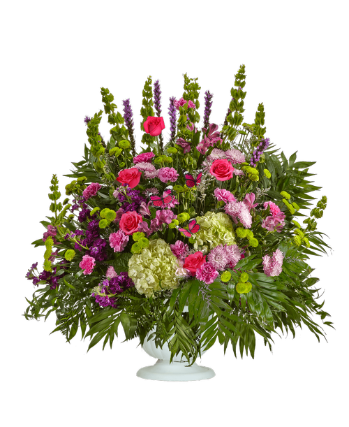 A one-sided arrangement from our Tranquil Funeral Collection, suitable to be sent to a funeral or memorial service, with roses, stock, Bells of Ireland, hydrangea, alstroemeria, carnations, daisy poms, liatris, button poms, liatris, and caspia designed in a 9.5 inch urn. Includes three Butterfly stick ins. 36 inchH x 40 inchW