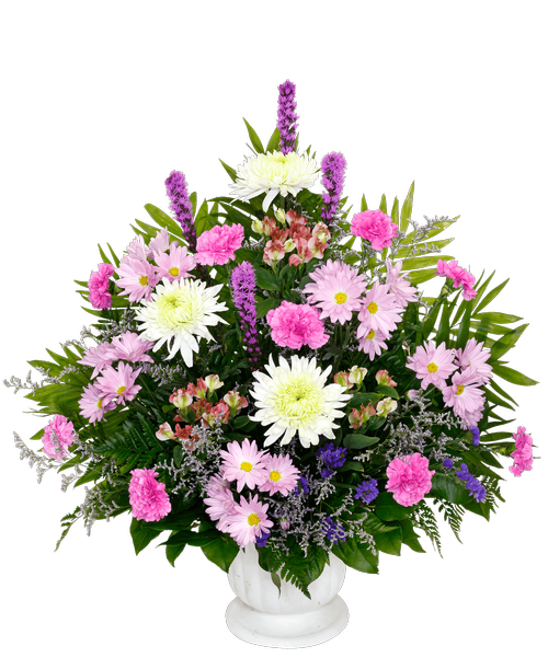 A one-sided arrangement, suitable to be sent to a funeral or memorial service, with football mums, liatris, carnations, charmelia alstroemeria, daisy poms, statice, and caspia designed in a 9.5 inch Pedestal Urn. 36 inchH x 26 inchW
