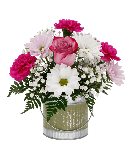 A 4 x 4.25 round silver metal tin with a green painted design and a metal handle holds an all around arrangement with a lavender rose, lavender carnations, white and lavender daisy poms, and baby's breath. 11 inchH x 10 inchW