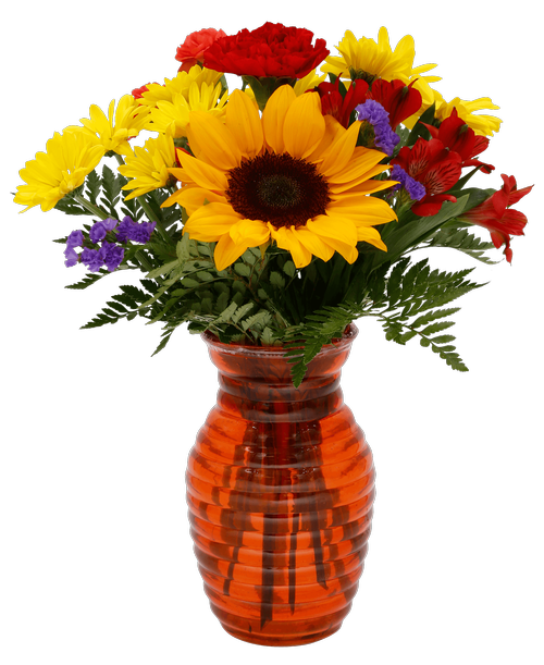 A 7.25 inchH orange glass vase with a horizontal design holds an all around arrangement with a sunflower, a carnation, alstroemeria, daisy poms, mini carnations, and statice. 15 inchH x 10 inchW