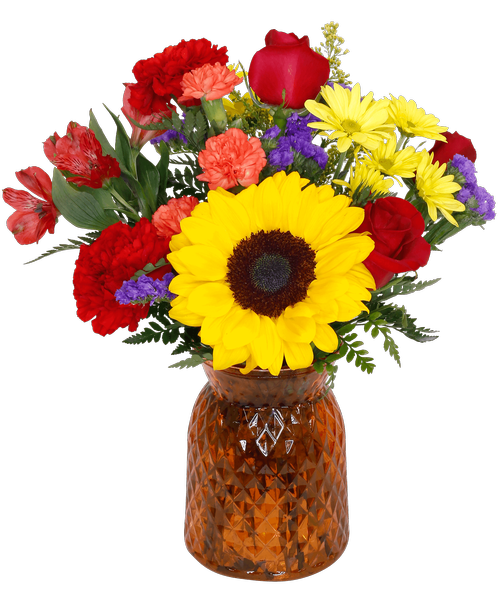 A 6.5 inchH orange glass vase with a diamond pattern holds an all around arrangement with three roses, a sunflower, carnations, mini carnations, alstroemeria, daisy poms, solidago and statice. 14 inchH x 10 inchW