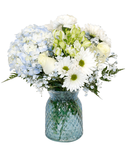 A 6.5 inchH blue glass vase with a diamond pattern holds an all-around arrangement with three roses, a hydrangea, charmelia alstroemeria, carnations, daisy poms, and blue-dyed baby's breath. 14.5 inchH x 9.5 inchW