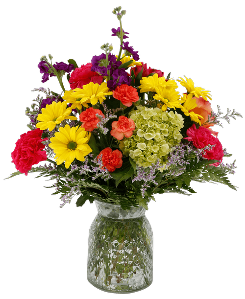 A 6.5 inchH clear glass vase with a diamond pattern holds an all around arrangement with an orange free spirit rose, purple stock, a mini green hydrangea, pink alstroemeria, hot pink carnations, orange mini carnations, yellow daisy poms, and caspia. 18 inchH x 13 inchW
