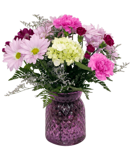 A 6.5 inchH lavender glass vase with a diamond pattern holds an all-around arrangement with a mini green hydrangea, alstroemeria, carnations, mini carnations, daisy poms, and caspia. 14.5 inchH x 11 inchW