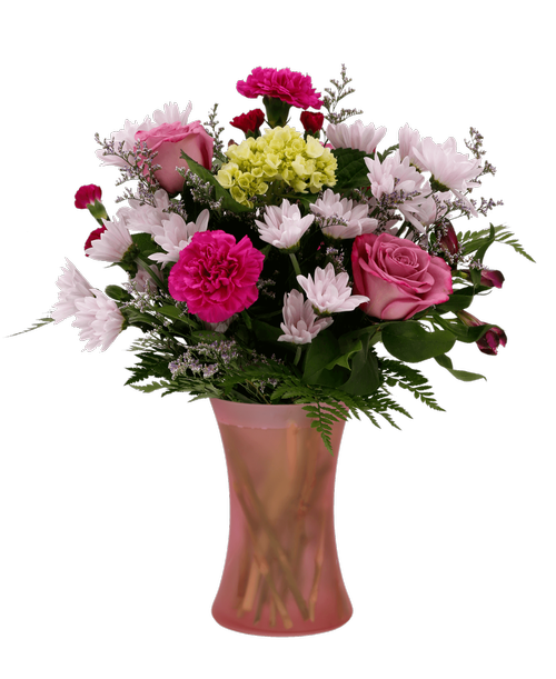 Tranquility with Roses is a floral arrangement featuring a mix of pink and purple flowers in a 7.5 inch pink dimpled glass vase. The vase contains three roses, a mini green hydrangea, carnations, mini carnations, alstroemeria, daisy poms, and caspia. This arrangement is perfect for expressing your sympathy, gratitude, or love to someone special. 17.5 inchH x 12 inch W