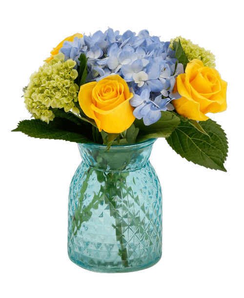 A 6.5 inchH blue glass vase with a diamond pattern holds three yellow roses, a blue hydrangea, and two mini green hydrangea. 11 inchH x 9 inchW