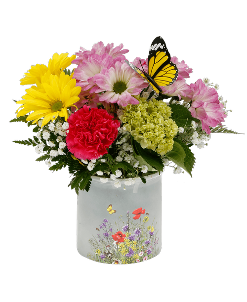 A 4.75' glass container with flower and a butterfly design holds an all around arrangement with a mini hydrangea, hot pink carnations, yellow daisy poms, pink daisy poms, baby's breath, and a butterfly stick in. 11 inchH x 9 inchW