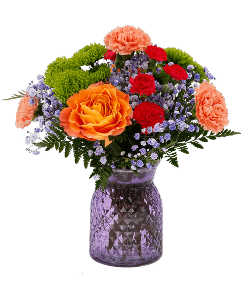 A 6.5 inchH lavender glass vase with a diamond pattern holds an all around arrangement with two orange free spirit roses, green cushions poms, orange carnations, hot pink mini carnations, and purple dyed babies breath. 15 inchH x 12 inchW