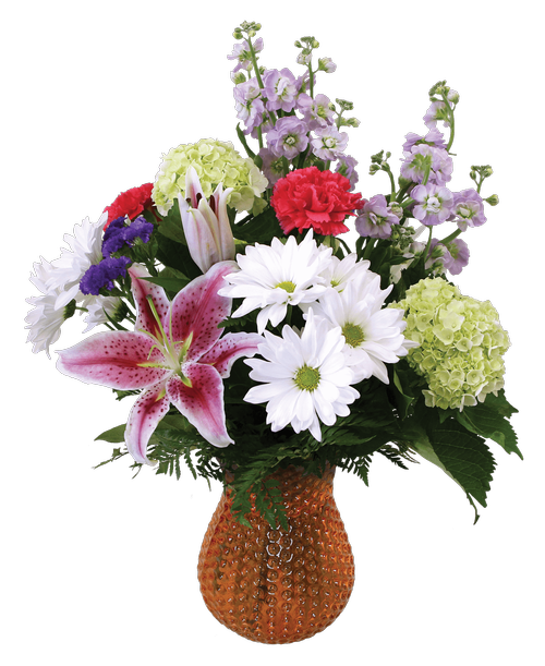 A 7.5 inch orange dimpled glass vase holds an all around arrangement with pink stargazer lilies, lavender stock, mini green hydrangea, hot pink carnations, white daisy poms, and purple statice. 16 inchH x 13 inchW