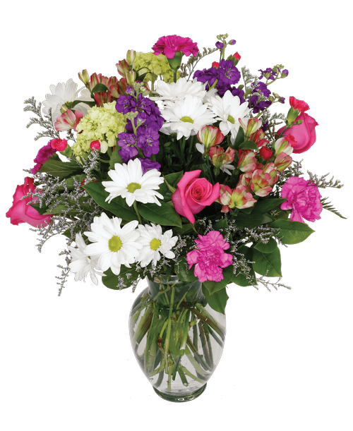 A 10 inchH clear glass vase holds an all -around arrangement with three pink roses, purple stock, mini green hydrangea, pink charmelia alstroemeria, lavender carnations, hot pink mini carnations, white daisy poms, and caspia. 23 inchH x 15 inchW