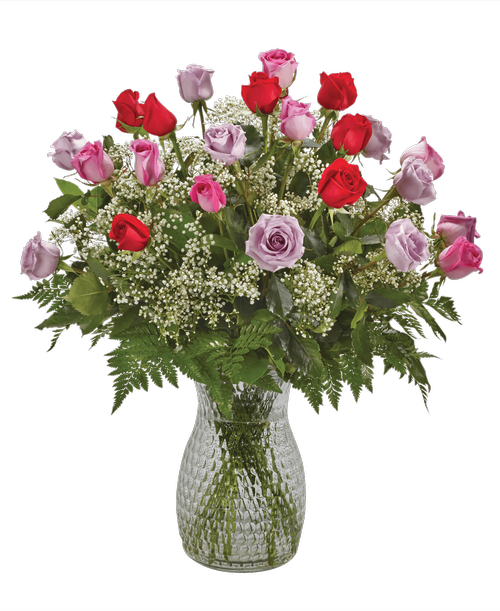 A striking arrangement of two dozen long-stemmed red, lavender and pink roses, and baby's breath in a 10 inchH pebbled glass vase. 28 inchH x 24 inchW