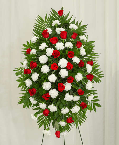 A standing spray from our Classic Rose & Carnation Funeral Collection, suitable to be sent to a funeral or memorial service, designed with roses and carnations. 42 inchL x 27 inchW - Displayed on a 54 inch Easel.
