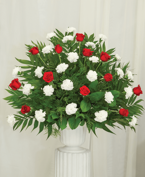 A one-sided arrangement from our Classic Rose & Carnation Funeral Collection, suitable to be sent to a funeral or memorial service, with roses and carnations designed in a 9.5 inch pedestal urn. 36 inchH x 36 inchW
