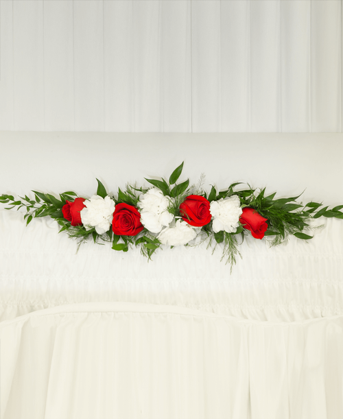 A ledgepiece from our Classic Rose & Carnation Funeral Collection to be placed inside the casket and suitable to be displayed at a funeral or memorial service, is designed with roses and carnations. 25 inchL x 5 inchW