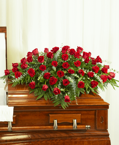 A half casket spray from our Beloved Funeral Collection designed with roses and assorted greens. 58 inchL x 48 inchW