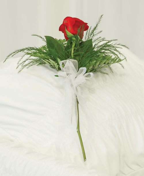 A memorial rose from our Beloved Funeral Collection with a rose, greens and a bow. 