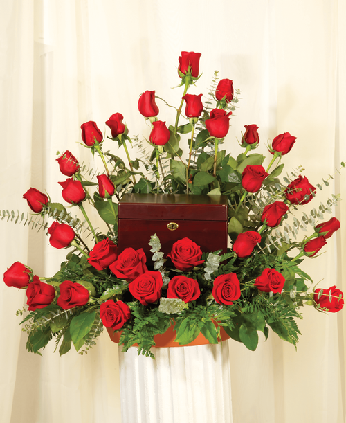 A memorial arrangement from our Beloved Funeral Collection with roses and assorted greens. Suitable for a funeral or memorial service with the option to display an urn, photograph or a special memento. 29 inchH x 30 inchW