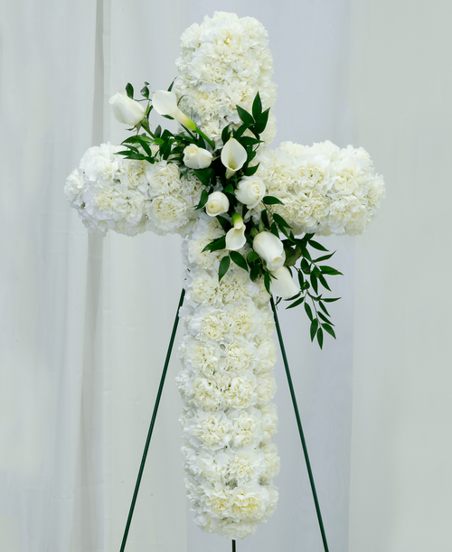 A 30 inch cross from our Celestial Funeral Collection, suitable to be sent to a funeral or memorial service, is designed using carnations, roses, calla lilies, and ruscus. 34 inchL x 20 inchW - Displayed on a 48 inch Easel
