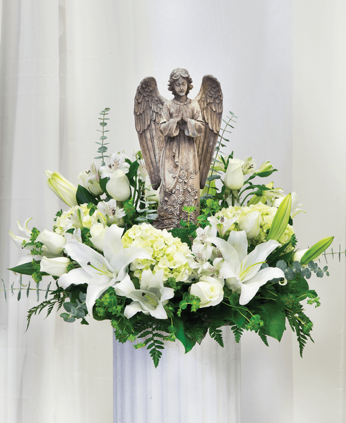A one-sided arrangement from our Celestial Funeral Collection, suitable to be sent to a funeral or memorial service, featuring a 15 inch Angel surrounded by roses, lilies, hydrangea, alstroemeria, and assorted greens. 24 inchL x 24 inchW x 16 inchH