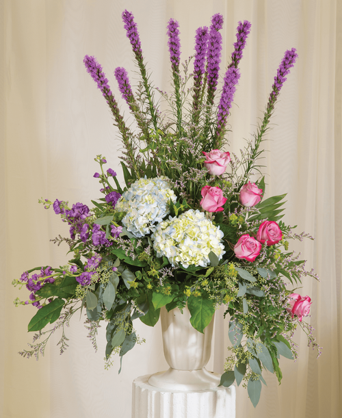 A one-sided arrangement from our Tranquil Funeral Collection, suitable to be sent to a funeral or memorial service, with roses, hydrangea, stock, liatris, caspia, and assorted greens designed in a 11-1/4 urn. 36 inchH x 30 inchW