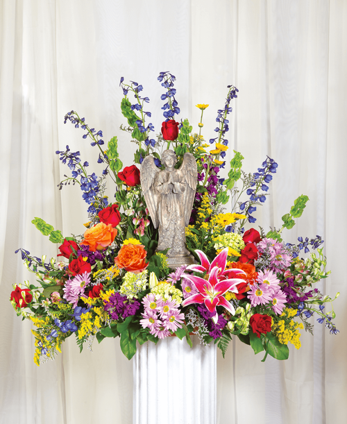 A beautiful memorial arrangement from our English Garden Funeral Collection, suitable to be sent to a funeral or memorial service, featuring a 15 inch praying angel keepsake with roses, hydrangea, bells of Ireland, lilies, stock, delphinium, alstroemeria, daisy poms, viking poms, solidago, caspia, and assorted greens. 31 inchH x 36 inchW