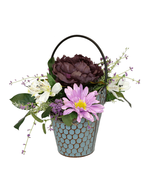 A 8.5 inchH teal honeycomb bucket holds an all around silk arrangement with a purple peony, white alstroemeria, lavender gerbera daisies and purple blossom. 11 inchH x 17 inchW; Overall 14 inchH with handle
