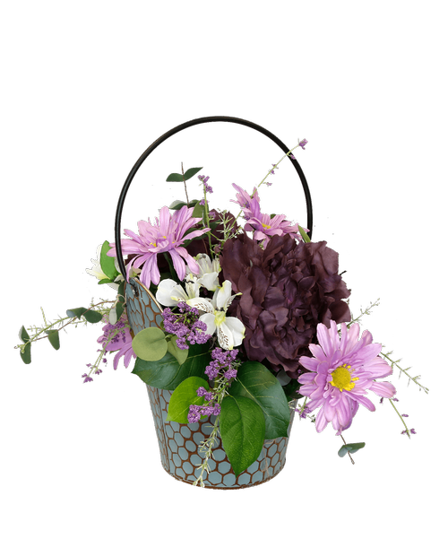 A 9.5 inchH teal honeycomb bucket holds an all around silk arrangement with purple peonies, white alstroemeria, lavender gerbera daisies and purple blossoms. Overall 16 inchH x 20.5 inchW