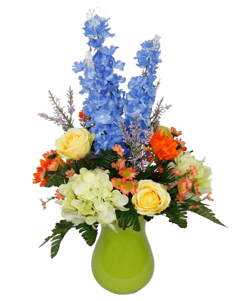 A 7 inchH ceramic green vase holds an all around silk arrangement with blue delphinium, yellow roses, orange gerbera daisies, green hydrangea, coral daisies, and lavender astilbe. 24 inchH x 15 inchW