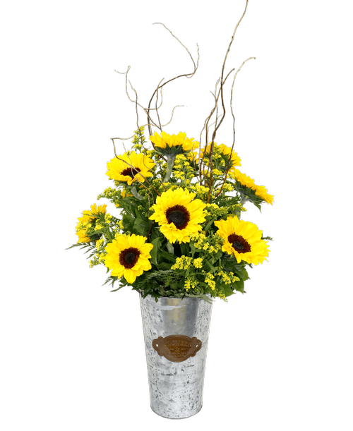 Brighten up your home or garden with this charming metal bucket arrangement. The bucket (13 inch H x 7 inch W) features a vintage-style plate that reads 'Flowers & Garden', and is filled with cheerful sunflowers, yellow solidago, and curly willow branches. This arrangement measures 27 inches high and 15 inches wide, with an additional 9 inches of height from the curly willow.