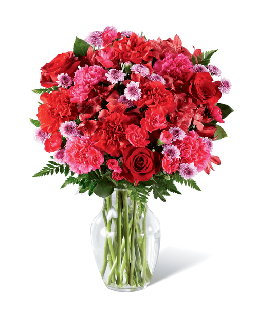 Brilliantly rosy in color, this fresh flower arrangement is out to have your recipient tickled pink with delight. Hot pink carnations and mini carnations start as the color base surrounded by the deeper red hues of roses, carnations, and Peruvian Lilies, accented with the lighter shade brought on by lavender button poms contrasting with assorted greens for a full and lush effect. Presented in a classic clear glass vase, this eye-catching flower bouquet is a standout thank you, thinking of you, or happy birthday gift. Approx. 16 inchH x 13 inchW.