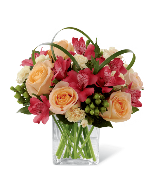 FTD proudly presents the Better Homes & Gardens All Aglow Bouquet. Light up their life with incredible color and blooming beauty when you send this exquisite flower bouquet. Unforgettable peach roses are surrounded by red Peruvian lilies, pale yellow mini carnations, green hypericum berries, lily grass blades and lush greens to create a stunning flower arrangement. Presented in a clear glass cube vase to give it a sophisticated look, this mixed flower bouquet will express your sweetest thank you, get well or congratulations wishes. 9 inchW x 10 inchH
