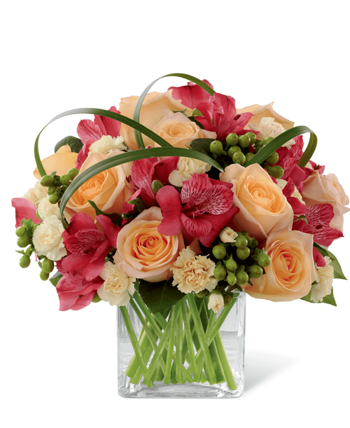 FTD proudly presents the Better Homes & Gardens All Aglow Bouquet. Light up their life with incredible color and blooming beauty when you send this exquisite flower bouquet. Unforgettable peach roses are surrounded by red Peruvian lilies, pale yellow mini carnations, green hypericum berries, lily grass blades and lush greens to create a stunning flower arrangement. Presented in a clear glass cube vase to give it a sophisticated look, this mixed flower bouquet will express your sweetest thank you, get well or congratulations wishes. 11 inchW x 10 inchH