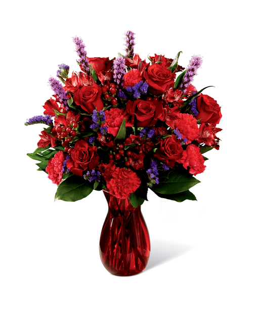 Love makes the world go round and this fresh flower arrangement is out to prove it with it's deep, romantic coloring and, oh, so sophisticated styling. Rich red roses mingle with red Peruvian Lilies, hot pink carnations, purple statice, red hypericum berries, liatris, and lush greens, elegantly arranged in ruby red glass vase to create an impactive visual affect. Bursting with love from every bloom, this bouquet is out to create a standout anniversary, birthday, or, I love you gift. Approx. 21 inchH x 16 inchW.