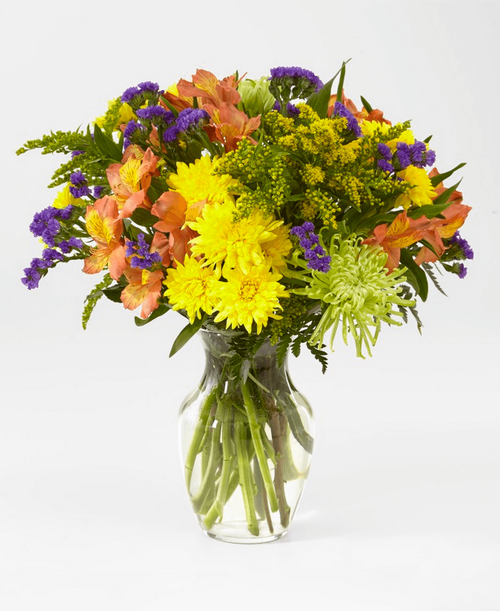 Flowers of yellow and green and pops of orange and purple. Full of color and texture, all you need is love and our Marmalade Skies Bouquet. 16 inchhx14 inchw