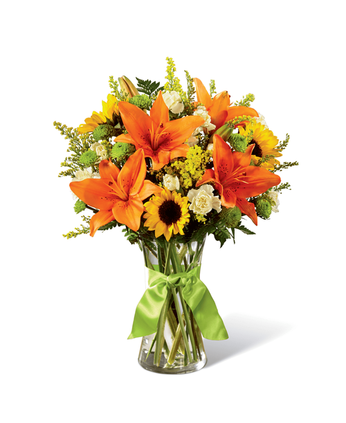 Speaking to rolling hills, blue skies, and time to breathe and relax, this sunlit bouquet is set to have your recipient finding joy in nature's beauty and light. Mini sunflowers, orange Asiatic Lilies, yellow mini carnations, green button poms, yellow solidago, and lush greens are arranged perfectly in a classic clear glass vase tied at the neck with a lime green satin ribbon. A simply gorgeous way to celebrate a birthday, say thank you, or send your warmest wishes for any of life's special moments! Approx. 16 inchH x 13 inchW.