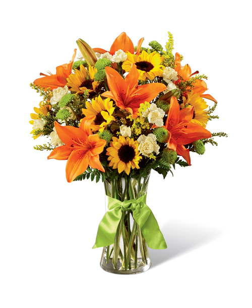 Speaking to rolling hills, blue skies, and time to breathe and relax, this sunlit bouquet is set to have your recipient finding joy in nature's beauty and light. Mini sunflowers, orange Asiatic Lilies, yellow mini carnations, green button poms, yellow solidago, and lush greens are arranged perfectly in a classic clear glass vase tied at the neck with a lime green satin ribbon. A simply gorgeous way to celebrate a birthday, say thank you, or send your warmest wishes for any of life's special moments! Approx. 18 inchH x 15 inchW.