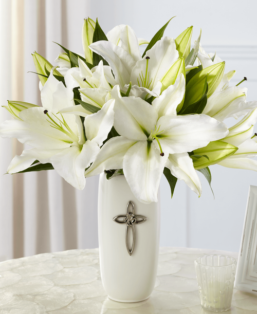 The FTD Faithful Blessings Bouquet is an incredible way to celebrate a communion, confirmation, or wedding, as well as, send your sympathy for the loss of a loved one. Bringing together stems of fragrant Oriental Lilies, boasting multiple blooms on each stem to create a full and lush flower bouquet, this offering of flowers will bring peace and beauty to any of life's special moments and occasions. Presented in a keepsake designer white ceramic vase with a stunning cross on the front, this exquisite flower arrangement is exudes heartfelt blessings with each eye-catching, star-shaped lily. Lilies may arrive in various stages of development. The lily blooms will continue to open, extending arrangement life - and your recipient's enjoyment. 16 inchW x 17 inchH