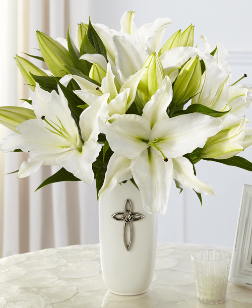 The FTD Faithful Blessings Bouquet is an incredible way to celebrate a communion, confirmation, or wedding, as well as, send your sympathy for the loss of a loved one. Bringing together stems of fragrant Oriental Lilies, boasting multiple blooms on each stem to create a full and lush flower bouquet, this offering of flowers will bring peace and beauty to any of life's special moments and occasions. Presented in a keepsake designer white ceramic vase with a stunning cross on the front, this exquisite flower arrangement is exudes heartfelt blessings with each eye-catching, star-shaped lily. Lilies may arrive in various stages of development. The lily blooms will continue to open, extending arrangement life - and your recipient's enjoyment. 17 inchW x 18 inchH