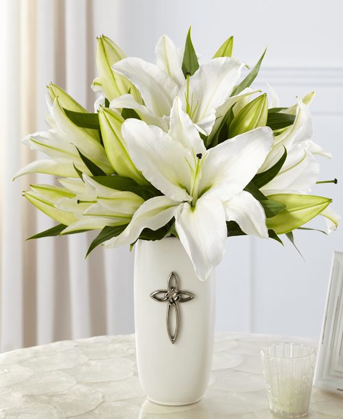 The FTD Faithful Blessings Bouquet is an incredible way to celebrate a communion, confirmation, or wedding, as well as, send your sympathy for the loss of a loved one. Bringing together stems of fragrant Oriental Lilies, boasting multiple blooms on each stem to create a full and lush flower bouquet, this offering of flowers will bring peace and beauty to any of life's special moments and occasions. Presented in a keepsake designer white ceramic vase with a stunning cross on the front, this exquisite flower arrangement is exudes heartfelt blessings with each eye-catching, star-shaped lily. Lilies may arrive in various stages of development. The lily blooms will continue to open, extending arrangement life - and your recipient's enjoyment. 15 inchW x 16 inchH