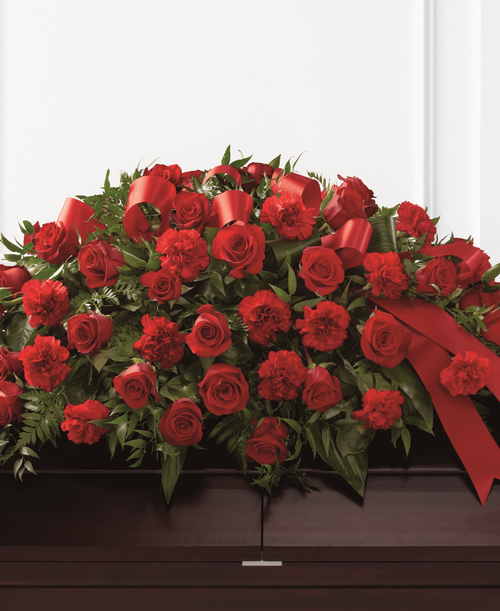 The FTD Dearly Departed Casket Spray bursts with the love and passion that the deceased had for their life and loved ones. Rich red roses and carnations are gorgeously arranged amongst lush greens and accented with a red satin ribbon to create the ideal adornment for their casket at their final farewell service. 40 inchW x 26 inchD