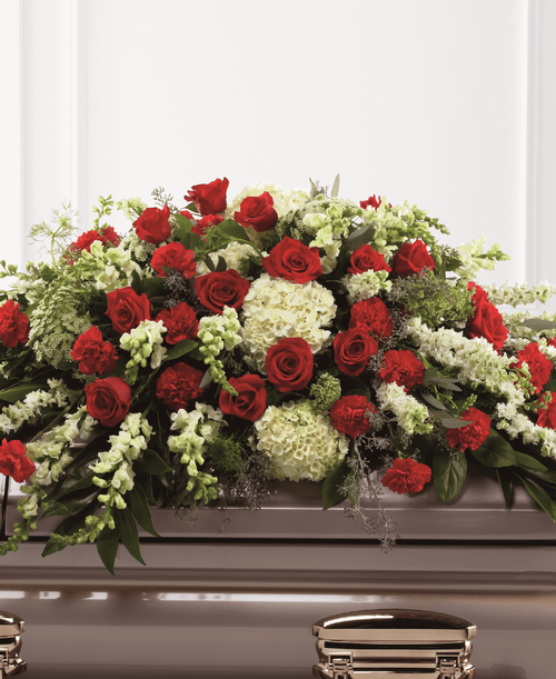 The FTD Sincerity Casket Spray is a wondrous presentation of fresh color and beauty. Rich red roses and carnations are eye-catching and elegant in an arrangement of white hydrangea, larkspur, snapdragons, Queen Anne's Lace and assorted lush greens to create a lovely display meant to bedeck the top of their casket, bringing comfort and peace to those grieving the loss of the departed. 48 inchW x 30 inchH