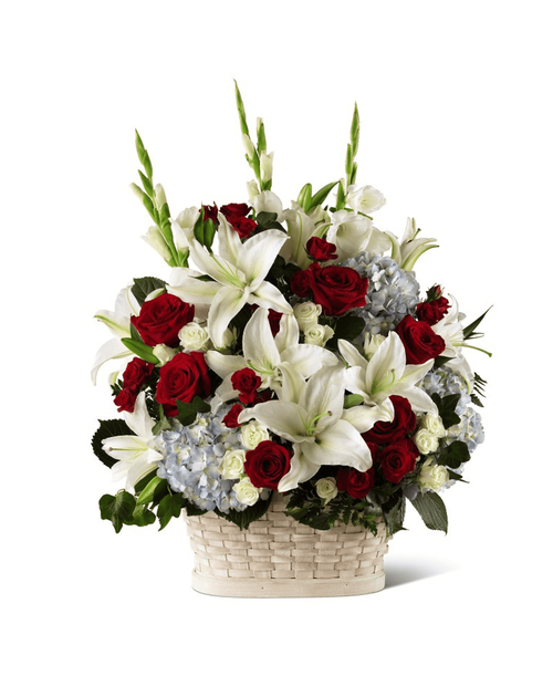 Honor the life of a true hero with patriotic blooms in a classic white basket. 27 inchHx21 inchW