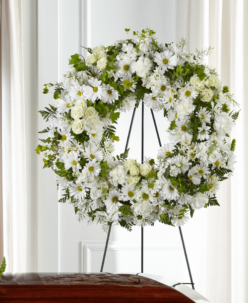 Your thoughtful messages are captured through a simple and elegant display of white flowers. Our Faithful Wishes Wreath combines classic white blooms in a timeless wreath t showcase your love, peace and respect. 
- Details:
Wreath is approximately 26 inch dia. 