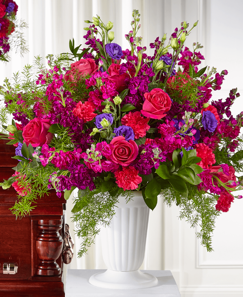 Whether it is a time of sensitivity or a celebration of life, a graceful mixture of purple and hot pink blooms reminds them of your compassion. Each rose, lisianthus, stock and carnation is complemented by a timeless white pedestal urn t share an uplifting message. 
Good arrangement is approximately 31 inchH x 31 inchW 
Better arrangement is approximately 31 inchH x 34 inchW 
