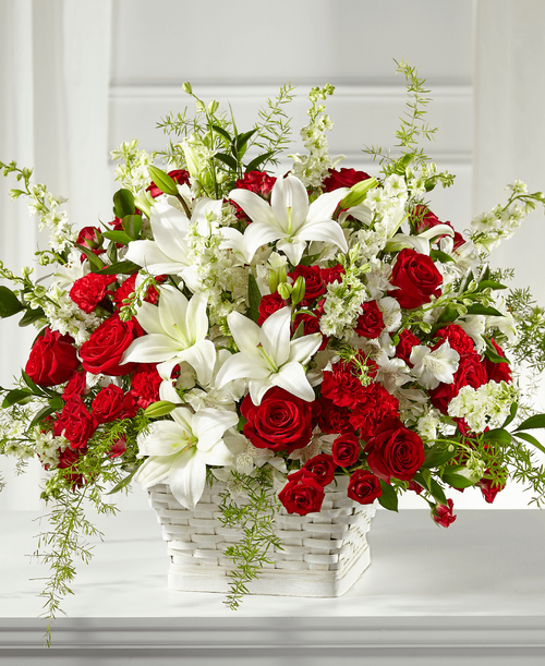 Our Sentiments of Love Arrangement is crafted with bold red and soft white blooms t beautifully display your respects during times of sensitivity. Each bloom is composed with grace and elegance as it is placed by a local florist in a white basket. It features a unique collection of lilies, roses, larkspur and carnations that is fit t send t either a home or service. 
Good arrangement is approximately 20 inchH x 25 inchW 
Better arrangement is approximately 22 inchH x 27 inchW 
Best arrangement is approximately 24 inchH x 29 inchW